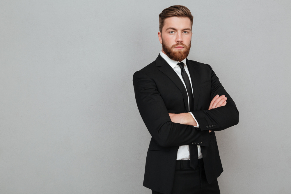 confident-young-businessman-suit-standing-with-arms-folded