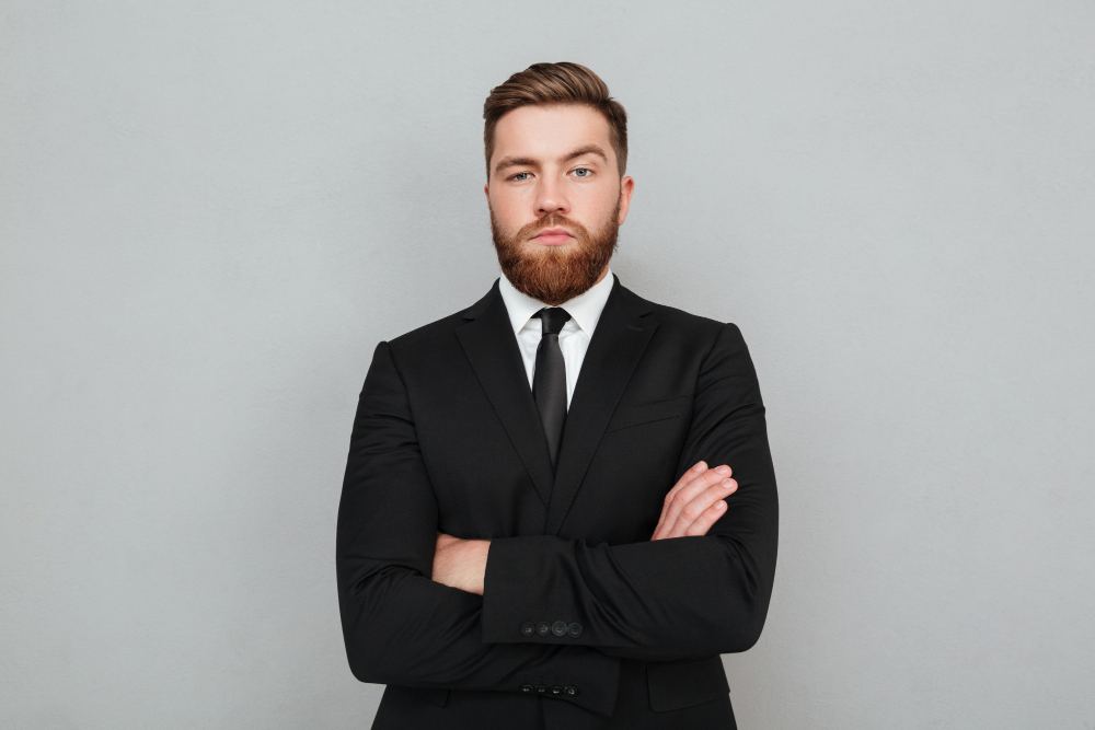 confident-young-businessman-suit-standing-with-arms-folded